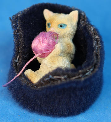 Cat in bed playing with yarn